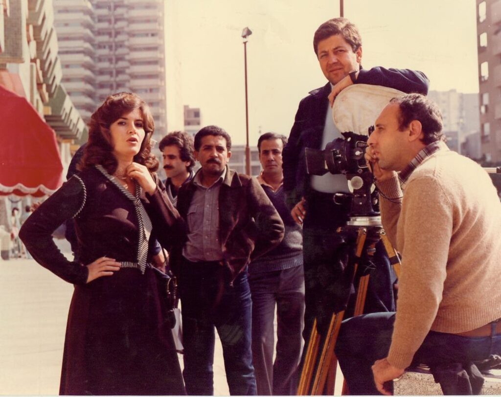 woman acting in front of camera surrounded by men